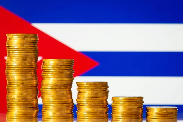 Golden coins in front of Cuba flag. Concept of economic recession of Cuba