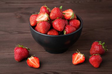 Strawberry in the bowl. Fresh ripe natural strawberry against black background