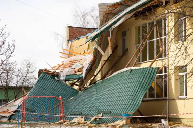 Ripped off roof laying near the building. Damage caused by the strong wind