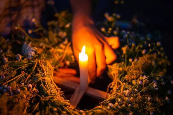 Close-up shot of a kupala wreath in girl`s hands on the river. Floating ritual wreath on the river with a candle, Ivan kupala celebration