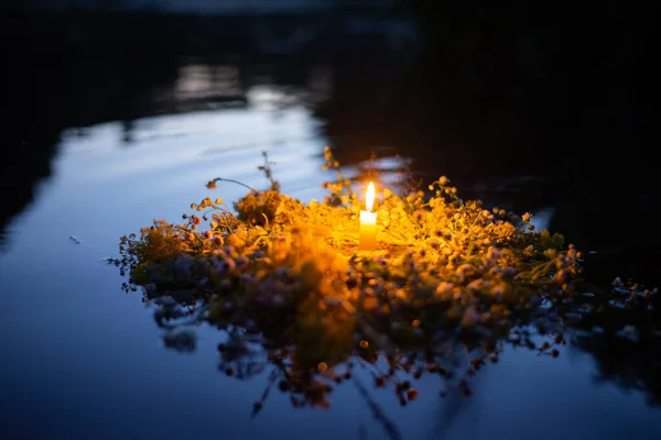 Wildflower wreath with a candle floating on the river. Ivan Kupala, Kupala traditions