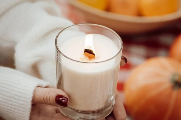 Hands of a woman holding glass candle. Aromatherapy concept
