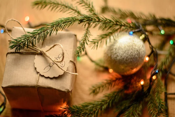 モミの木の枝 クリスマスの装飾ボール 木製のテーブルの上のライトの近くの新年プレゼントボックス — ストック写真