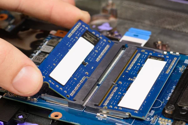 Installing new RAM memory chips to the laptop. Repairing and upgrading laptop at home