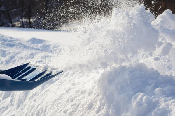 掃除中に雪を投げる男 晴れた冬の日にシャベルで雪を取り除く — ストック写真