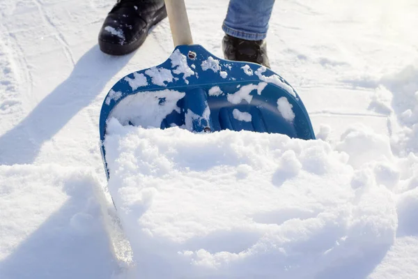 郊外の民家の前で狭い道を掃除している若者 日当たりの良い冬の朝に大雪の後に雪を掘る — ストック写真