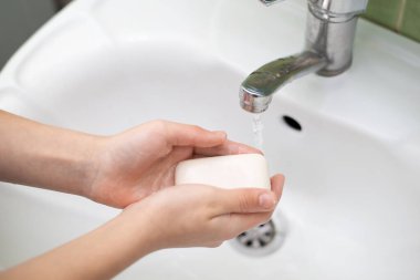 Çocuk ellerini yıkamak için sabun kullanıyor. Kişisel hijyen kavramı