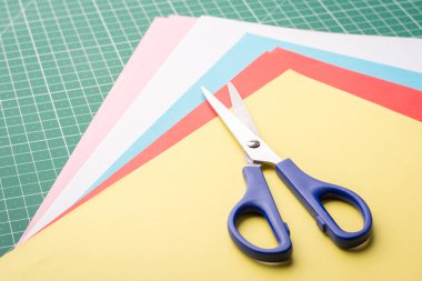 Renkli kağıtların üzerinde makas.