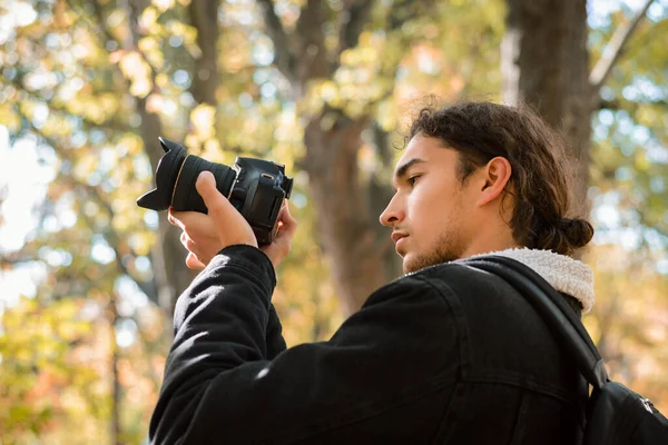 业余自然摄影师在秋天的森林里拍照 看着相机的屏幕 拍摄秋天森林的风景 — 图库照片