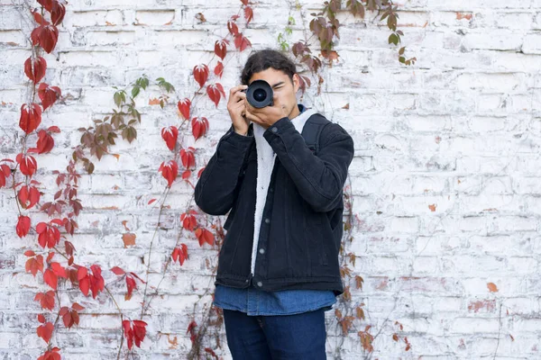白い壁の背景の近くに立って誰かを撮影若い初心者の写真家の肖像画 仕事中の写真家 — ストック写真