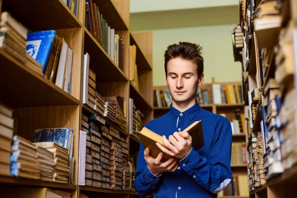 Jovem Estudante Entre Estantes Livros Biblioteca Lendo Livro Apreciando Seu — Fotografia de Stock