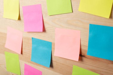 Tahta masaya rastgele yerleştirilmiş yapışkan kağıtlar. Beyin fırtınası kavramı