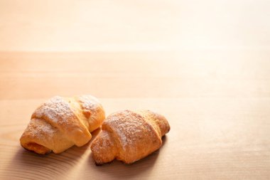 Kopya alanı olan ahşap masada iki taze kruvasan kurabiyesi. Ev yapımı fırın.