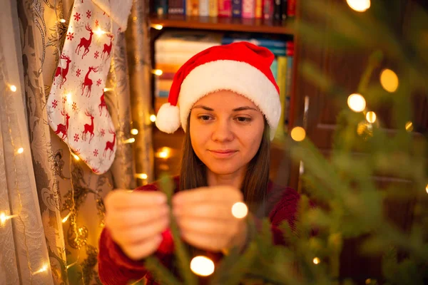 Veselá Dívka Santa Klobouku Visí Vánoční Cetka Vánoční Stromeček Jasnými — Stock fotografie
