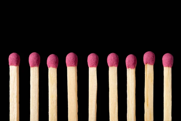 Row of pink matches on a black background, close up. Nice looking safety matches, isolated.