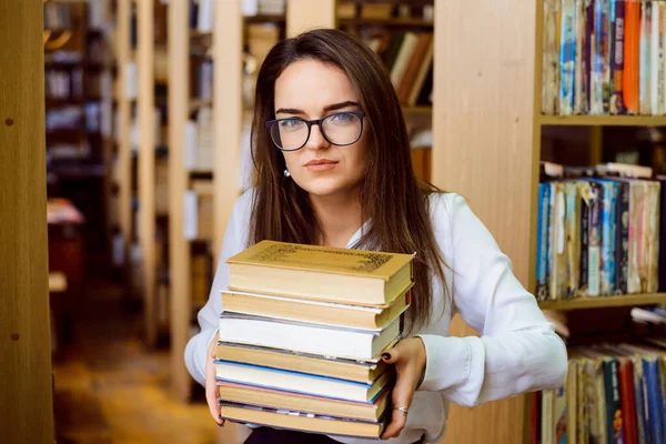 図書館に本がたくさんある女子学生 試験の準備をする弱虫の女の子 病気や絶え間ないハード学習の疲れ — ストック写真