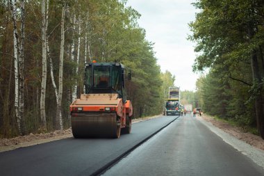 Yol silindiri kalınlaşması yeni asfalt şeridi oluşturdu. Kırsalda yol inşaatı