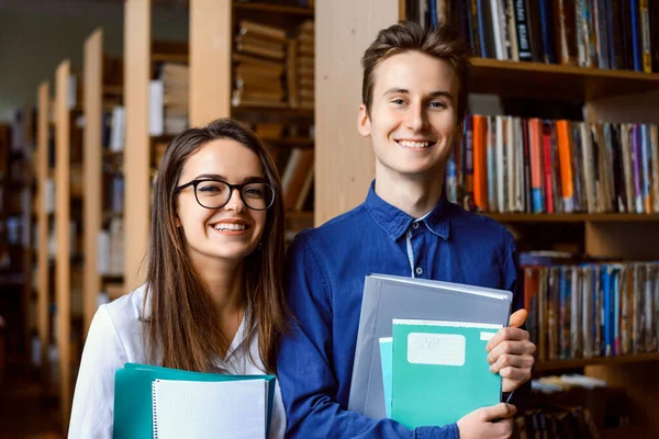Χαμογελώντας Άνδρες Και Γυναίκες Μαθητές Στη Βιβλιοθήκη Στέκονται Κοντά Ράφια — Φωτογραφία Αρχείου