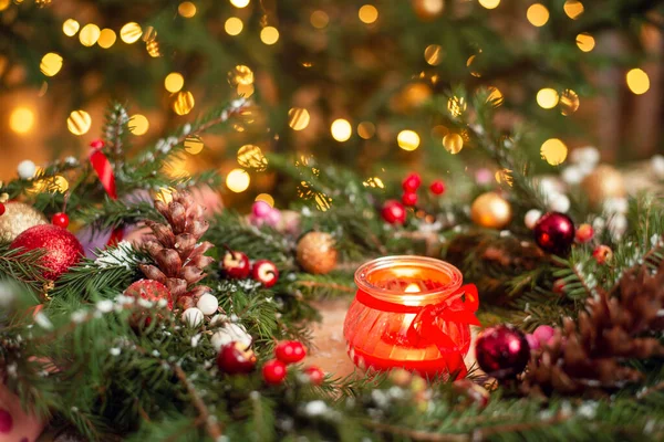 鮮やかなカラフルな背景を持つクリスマスの花輪で赤い燃焼キャンドルのショットを閉じます お祭りのクリスマス気分 — ストック写真