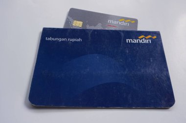 Yogyakarta, Endonezya - 17 Temmuz 2022. Banka Mandiri hesap defteri ve banka kartı resimleri. Kayıt defteri veya geçiş defteri, bir bankacı ve müşteri arasındaki işlemlerin bir kaydıdır..