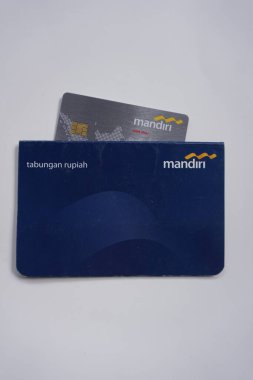 Yogyakarta, Endonezya - 17 Temmuz 2022. Banka Mandiri hesap defteri ve banka kartı resimleri. Kayıt defteri veya geçiş defteri, bir bankacı ve müşteri arasındaki işlemlerin bir kaydıdır..