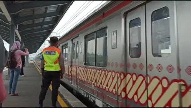 Yogya, ID - July 16th, 2022. Train attendant is working his job while the train is arriving. KRL or commuter line of Jogja - Solo is arriving at Brambanan Sation.