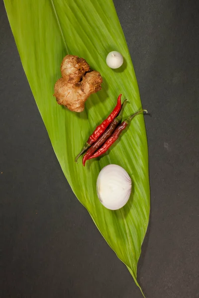 Chilli onion garlic ginger is placed on a turmeric leaf