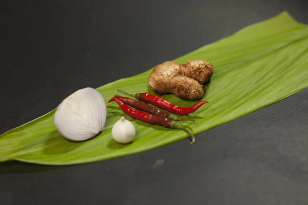 Chilli onion garlic ginger is placed on a turmeric leaf