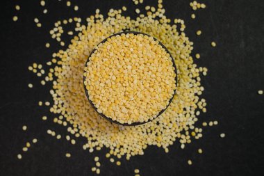 Siyah arka planda bir kasede çiğ kinoa tohumları