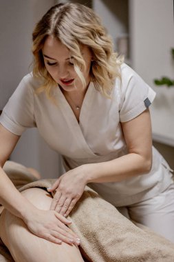 Kilo kaybı ve vücut düzeltmesi için vücudun sorunlu bölgelerine masaj yapın. Usta masaj terapisti genç bir kıza anti-selülit masajı yapıyor. Spa tedavileri rahatlatıcı masaj.