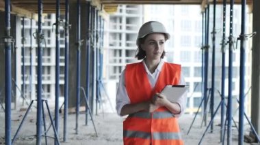 İnşaat alanında çalışan mühendis ya da mimar. İnşaat alanında tabletli bir kadın. İnşaat konsepti.