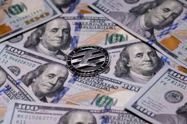 Gümüş Litecoins madeni parası ve 100 dolarlık banknotlar. Dijital kripto para birimi yakın plan. Değişim, meşguliyet, reklam. Madencilik kripto paralarından kazanç.