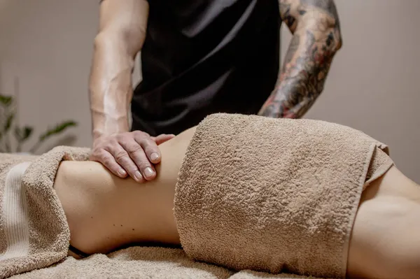 Primo piano del terapeuta che fa massaggi allo stomaco sulla donna nella spa — Foto Stock