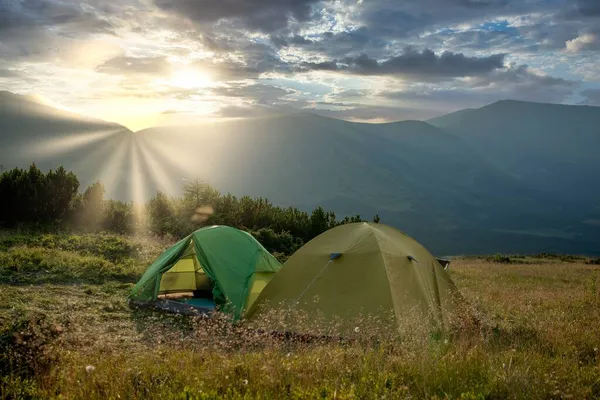 Utsikt över turisttält i bergen vid soluppgång eller solnedgång. Camping bakgrund. Äventyrsresor aktiv livsstil frihet koncept. Sommarsemester. — Stockfoto