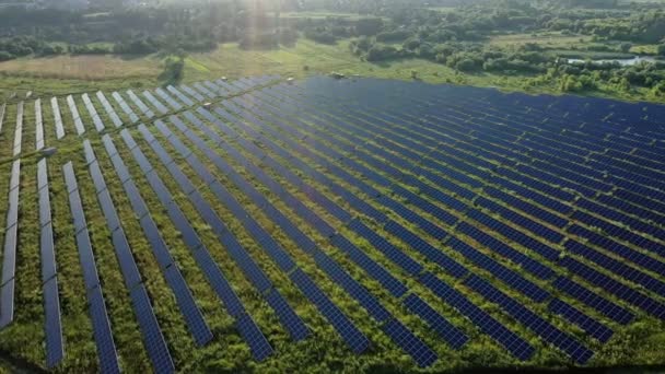日没のフィールドに位置する大規模な太陽光発電所のトップビュー 太陽光発電所 生態系のクリーンエネルギー 代替太陽駅 — ストック動画