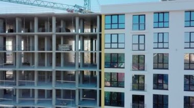 İnşaat halindeki yüksek apartmanın havadan görüntüsü. Yeni apartman cephesinin birçok penceresi yapım aşamasında. Gayrimenkul geliştirme