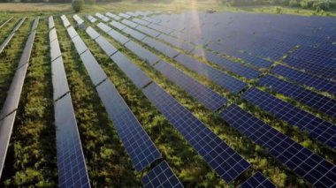 Güneş panellerinin hava görüntüsü gün doğumunda duruyor. Üstgeçit Alanları Yeşil Enerji Peyzajı. Elektrik Gücü, Ekoloji, Yenilik, Küresel Isınma kavramı.