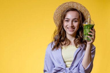 Yaz içeceği. Soğuk içecek. Elinde plastik bardakta alkolsüz içki olan genç bir kadın. Arındırılmış limonata. Tatil gevşemesi.