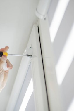 Adam pencerelere kaset silindirleri kuruyor.