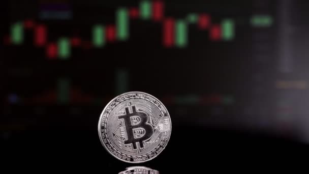 Munt Bitcoin op achtergrond cryptogeld trading chart op computerscherm. Digitaal geld, bankieren, beleggen, financiën en bedrijfsconcept. — Stockvideo