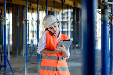 İnşaat alanında çalışan mühendis ya da mimar konsepti. İnşaat alanında tabletli bir kadın. Mimarlık Bürosu.