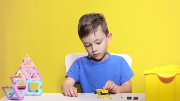 Умный мальчик делает машину с детским дизайнером — стоковое видео