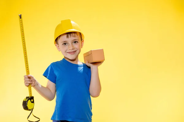 Boy Construction Helmet Holds Brick His Hands Measures Tape Measure — Fotografia de Stock