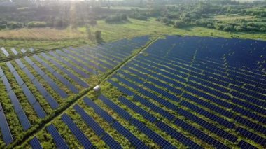 Güneş panellerinin hava görüntüsü gün doğumunda duruyor. Üstgeçit Alanları Yeşil Enerji Peyzajı. Elektrik Gücü, Ekoloji, Yenilik, Küresel Isınma kavramı.