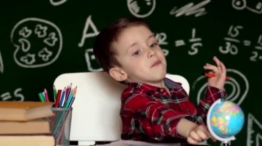 Ev ödevi yapan sevimli çocuk, boyama sayfaları, yazı ve resim. Çocuklar resim yapar. Çocuklar çizer. Evde kitapları olan bir anaokulu öğrencisi. Anaokulu öğrencileri yazmayı ve okumayı öğrenirler. Yaratıcı çocuk.