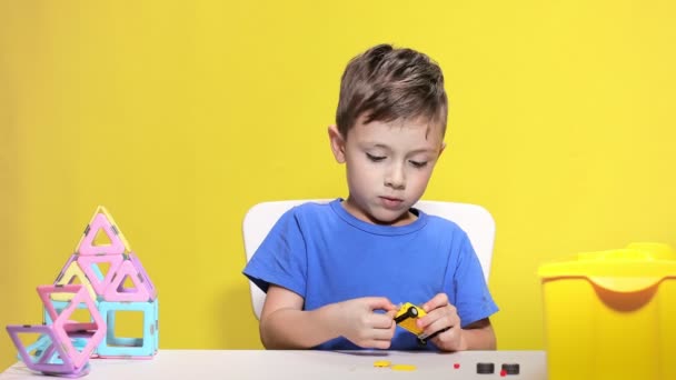 Clever little boy makes car with childrens designer — Wideo stockowe
