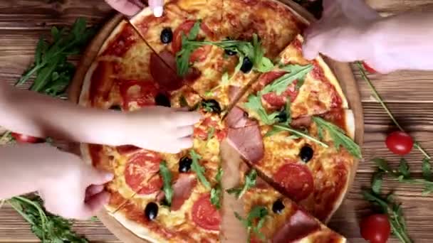 Οι άνθρωποι παίρνουν τις φέτες της πίτσας. Pizza and Hands close up πάνω από ξύλινο φόντο. — Αρχείο Βίντεο