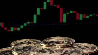 Birçok altın bitcoin bir ticaret grafiği ile arka planda döner. fiziksel bitcoin, dijital para birimi, şifreleme para birimi, btc.