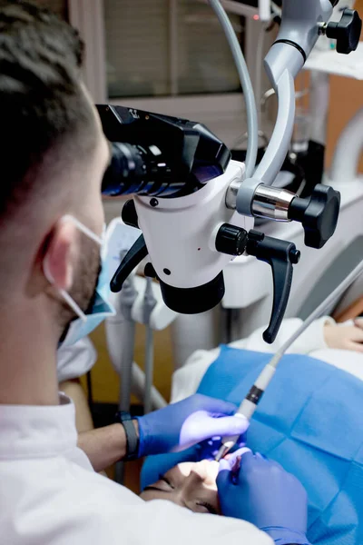 牙医通过显微镜观察病人的牙齿 现代渐进式牙科学 — 图库照片