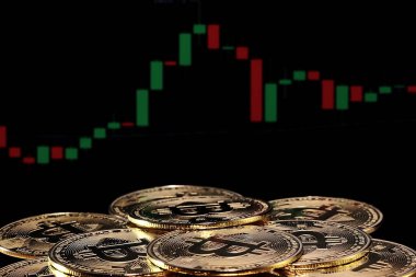 Birçok altın bitcoin bir ticaret grafiği ile arka planda döner. fiziksel bitcoin, dijital para birimi, şifreleme para birimi, btc.